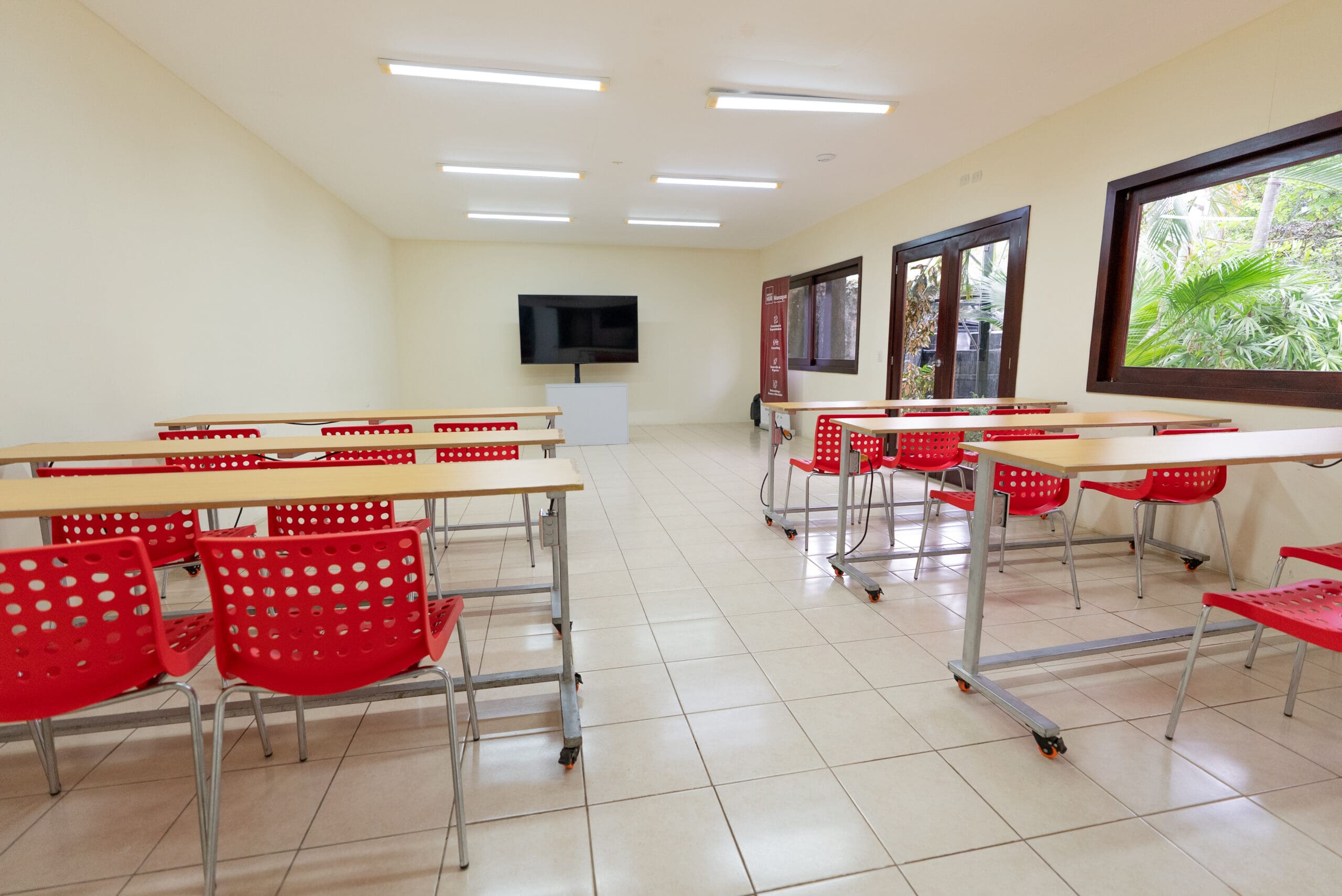 Salón de Impact Hub Managua con mesas y sillas para capacitaciones