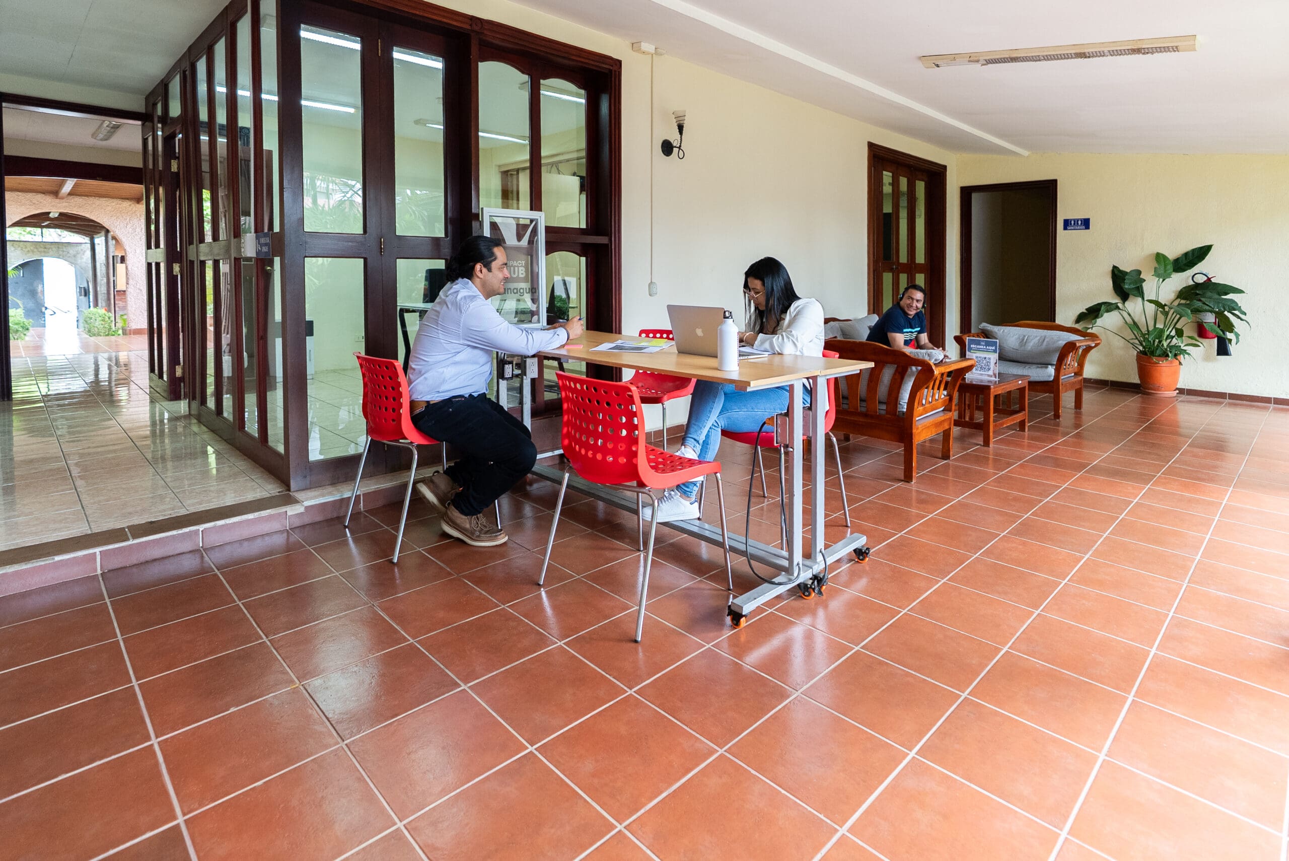 Personas trabajando en las áreas compartidas de Impact Hub Managua